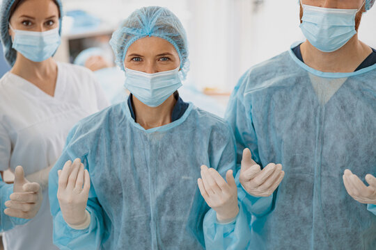 Team of surgeons in the operating room ready for surgery and waiting on patient and looking camera