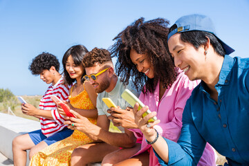 Group of young best friends bonding outdoors - Multiracial people bonding and having fun at the beach during summer vacation