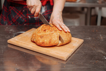 baker cuts bread with a khife