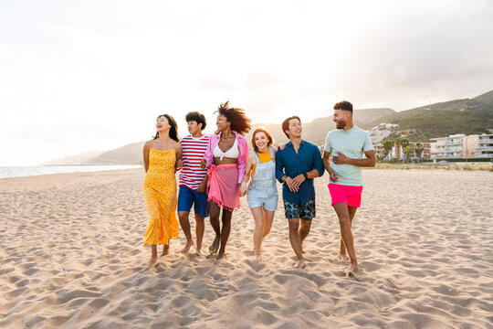 Group of young best friends bonding outdoors - Multiracial people bonding and having fun at the beach during summer vacation