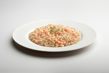 Fototapeta na wymiar Risotto with shrimps and parsley in white plat