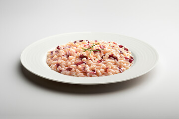 Fototapeta na wymiar Risotto with Treviso red radicchio and chives in white plate