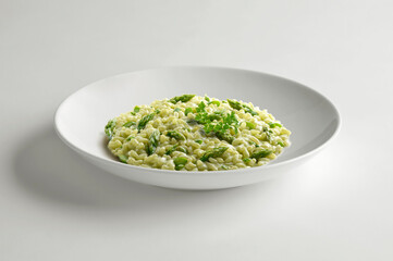 White bowl of risotto with green asparagus and parsley