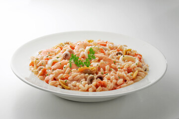 White bowl with fish and tomato risotto and parsley