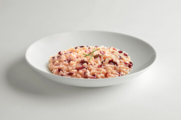 Fototapeta na wymiar White bowl with risotto with Treviso red radicchio and chives