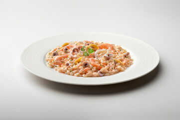 White dinner plate with fish risotto and parsley