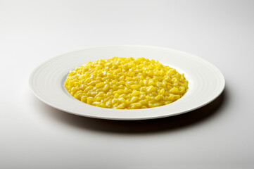 White flat plate with saffron risotto