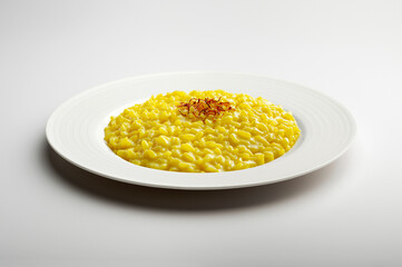 Yellow risotto and saffron pistils in white plate