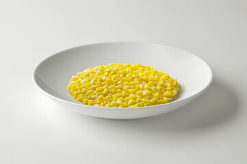 Yellow saffron risotto in white bowl