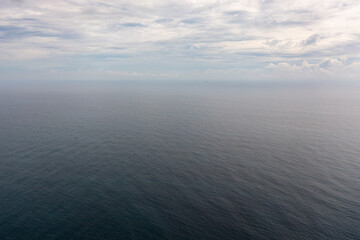 Top view of blue sea with waves and sky with clouds. Ocean skyline.