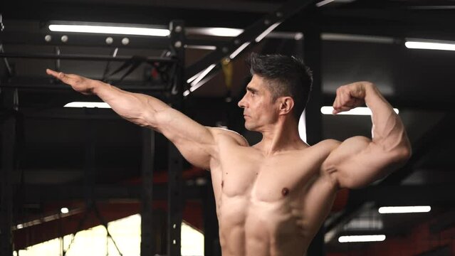 muscular man showing off posing like bodybuilder at gym, bodybuilding
