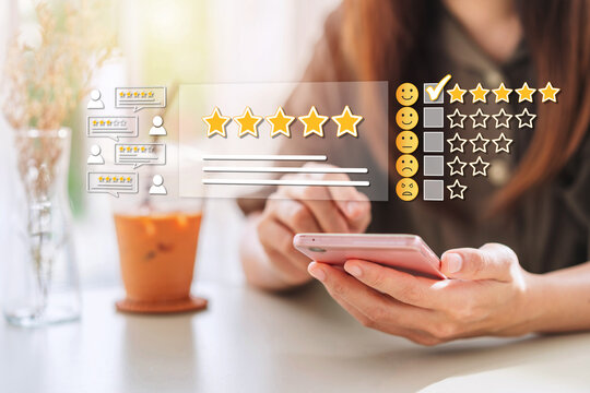 Young woman traveler using smartphone to give a five-star satisfaction rating of the food and drinks at restaurant on social media, Travel lifestyle concept
