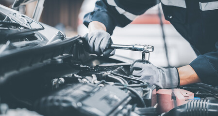 Mechanic works on the engine of the car in the garage. Repair se