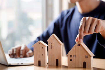 Men holding house model in hand and calculating financial chart for investment to buying property.	
