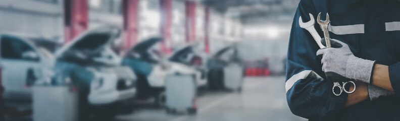 Hands of car mechanic with wrench in garage.Car care maintenance and servicing concept.