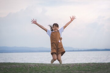 Fototapeta premium Smile happy girl jumping on the beach in summer vacation