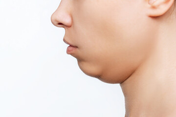 Cropped shot of a young caucasian woman's face with double chin isolated on a white background. Overweight, flabby and sagging skin. Profile - obrazy, fototapety, plakaty