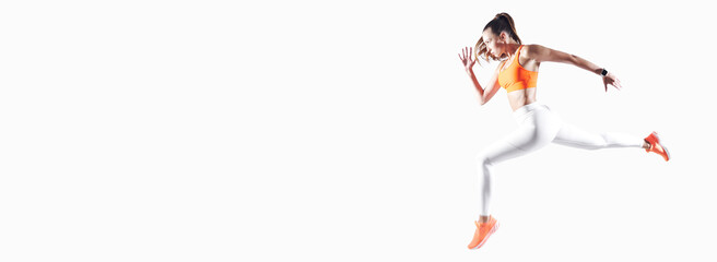 Confident young woman in sports clothing running against white background