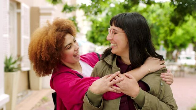 Portrait of two happy female friends meeting outside in the city. Diverse women embracing and hugging each other while spending the day together as besties outdoors, enjoying fun and free time