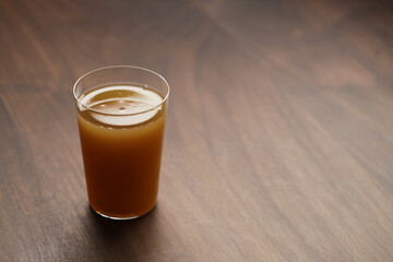 Apple celery juice in thin glass on wood table