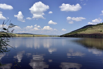 Cumulus clouds between a blue sky ans lake waters