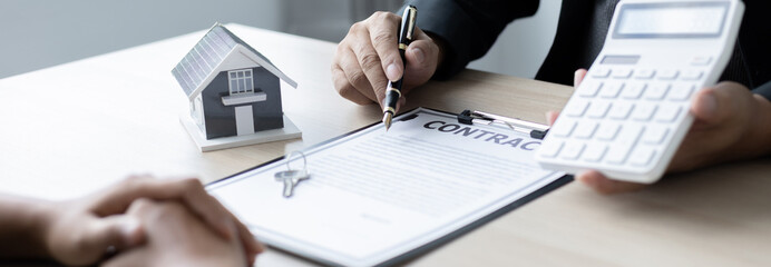 Real estate agent or sales manager talks to clients about the terms of buying a home and collateral...
