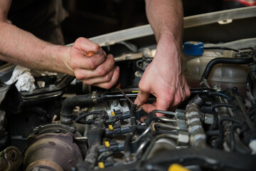 Technician removing fuel injectors in engine room checking dust and test pressure in maintenance process.