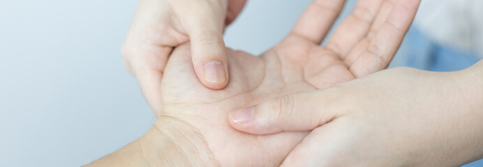 Physical therapy, Female physiotherapist treats hand and joint pain for a male patient attending in clinic, Bone arrangement, Non-surgical medical treatment, Modern medical techniques.