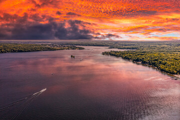 Penetanguishene Ariel drone shot during sunset  with boats in the lake and the clouds reflecting on the water 