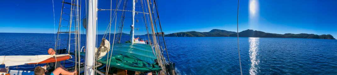 Sailing along beautiful islands scenario. Panoramic seascape sunset view from the sailing ship