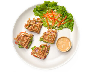 Belgian waffles on white plate with greens closeup