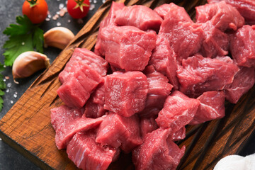Raw chopped beef meat. Raw organic meat beef or lamb, spices, herbs on old wooden board on dark...