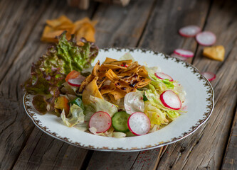 fatoosh salad served in a dish isolated on wooden background side view