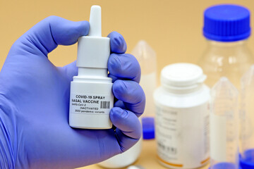 Scientist's hand holding a nasal vaccine tube against the SARS-Cov-2 coronavirus that causes...