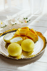 Tasty dessert Mochi with mango fruit on wooden background, close up. Traditional Japanese rice cake dessert