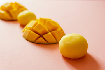 Tasty dessert Mochi with mango fruit on pink background, close up. Traditional Japanese rice cake...