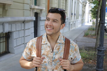 Handsome adult student with backpack and Hawaiian style shirt
