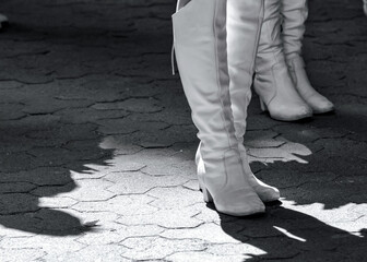 High white boots on the feet of the members of the majorette team.