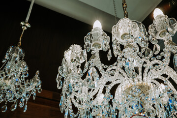 Beautiful czech crystal chandeliers on ceiling in dark night. Glass crystals hanging on vintage...