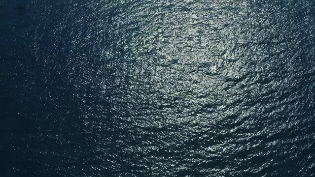 Aerial view of the sea with the reflection of the sun in the blue water. 