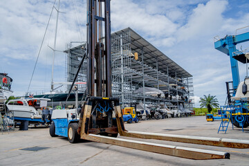 Forklift loading speedboats in a garage system in the marina