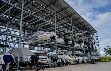 Speed motor boats are stapled in a garage system in the marina