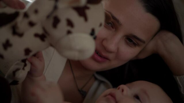 Newborn Baby With Young Mom look Into Each Other Eye. Cute Smiling Teethless Kid Face Portrait. Woman Kissing With Child Look At Camera. Infant, Mother Day, Childbirth, Beginning, Relationship Concept