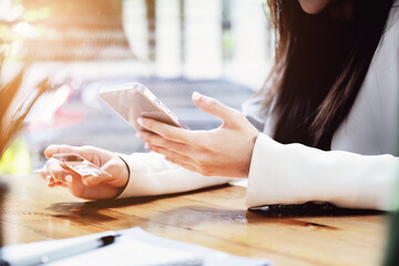 Asian young woman using a mobile phone and credit card for online shopping
