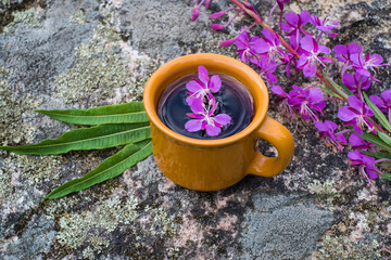 Obraz na płótnie Canvas Ivan tea or chai. Herbal tea from fireweed flowers in a cup on natural stone background. Traditional Russian kopor tea.