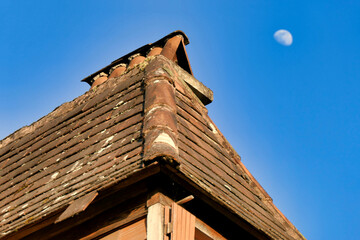 Old roof on a dormer window of a 200 year old French farmhouse in a state of disrepair with loose,...