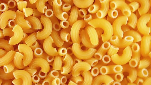 Uncooked Chifferi Rigati Pasta - Top View. Fat and Unhealthy Food. Classic Dry Macaroni, Slowly Rotating Background. Italian Culture and Cuisine. Raw Golden Pasta Texture - RIght Angular Rotation