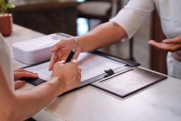 Close up of hand filling up the form or signing document. Bank loan, financial deal, medical...