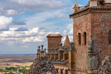 View of medieval buildings in Cáceres (Spain) illuminated by sunset light on a cloudy afternoon in...
