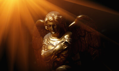 Praying angel with arms across chest. Ancient statue in the sunrays